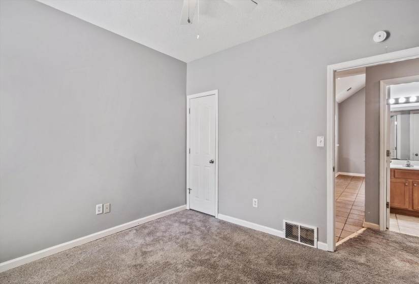 Bedroom featuring neutral wall paint, gray carpeting, white baseboards, and a ceiling fan
