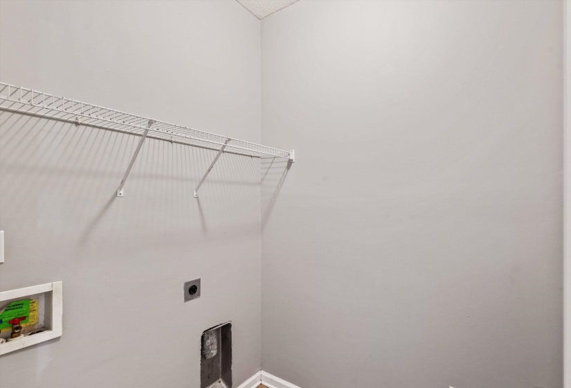 Dedicated laundry area featuring a wire rack shelving system and light gray wall paint