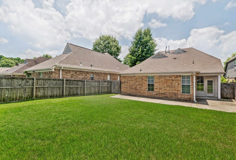 Expansive green lawn with a full wooden privacy fence