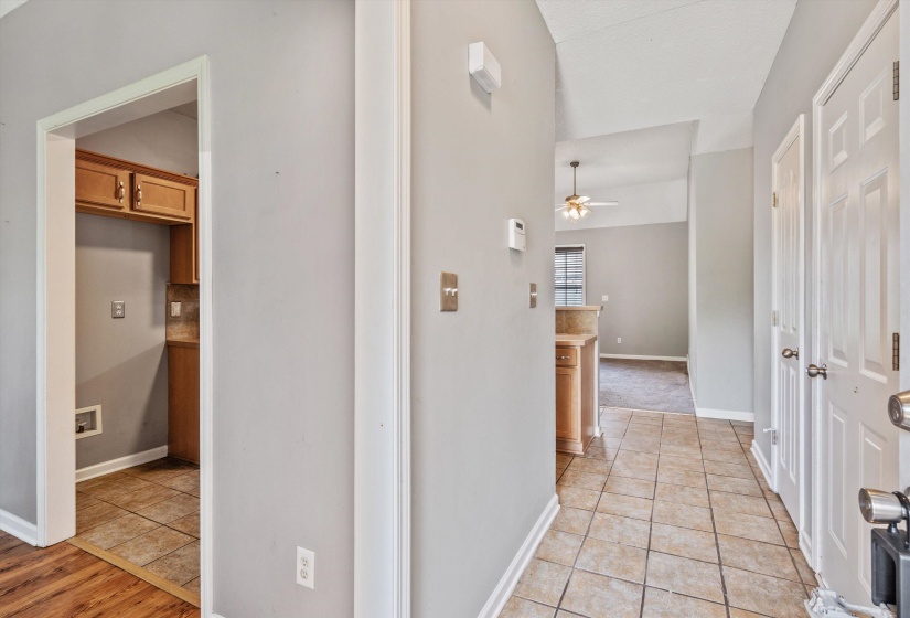Foyer featuring neutral tile flooring, light gray wall paint, and white trim