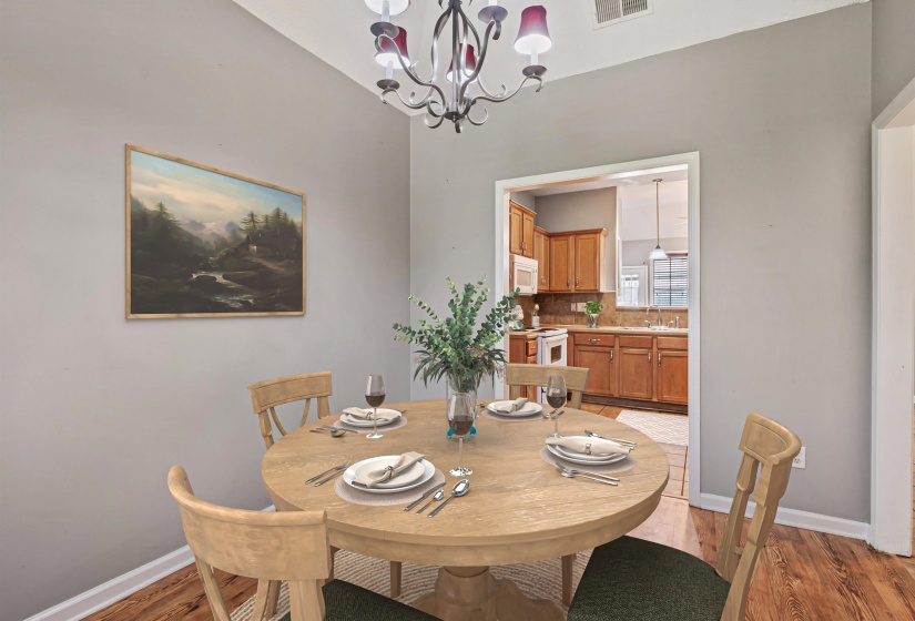 Dining area featuring a classic chandelier, light gray walls, and wood-finish flooring