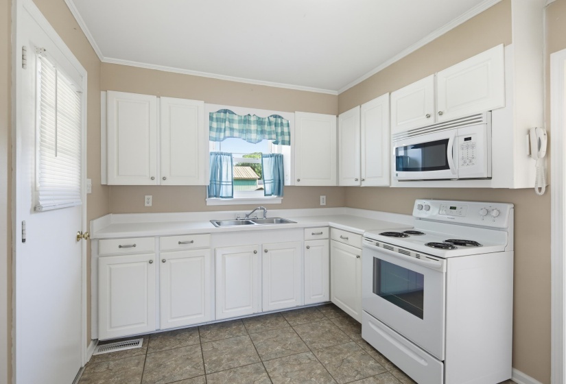 Kitchen featuring white cabinetry, a white electric range, and an over-the-range microwave