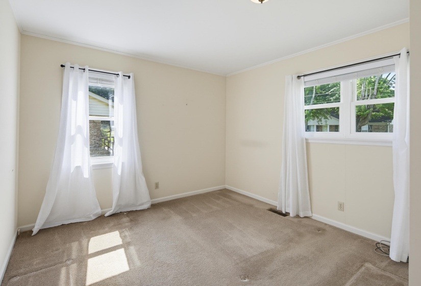 Carpeted room with neutral wall paint and white trim. Full Bathroom attached.