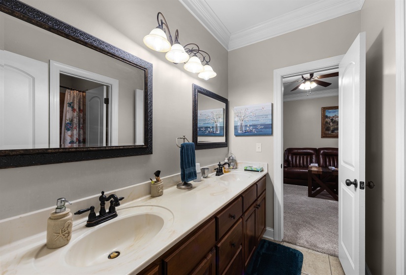 Bathroom featuring ornamental molding, double vanity,  ceiling fan, and a shower