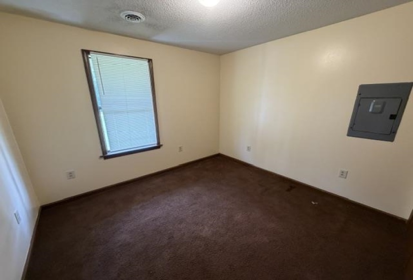 Interior room featuring light-colored walls and brown carpet flooring