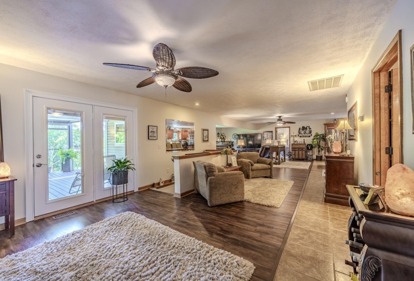 Spacious interior featuring wood-finish flooring, a ceiling fan, and French doors opening to a deck