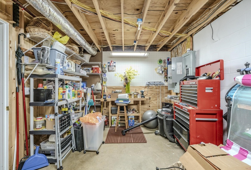 Unfinished basement space featuring exposed wood joists, ductwork, and electrical wiring