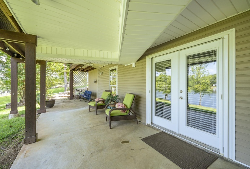 Covered outdoor patio featuring a concrete surface, wood posts, and a white beadboard ceiling