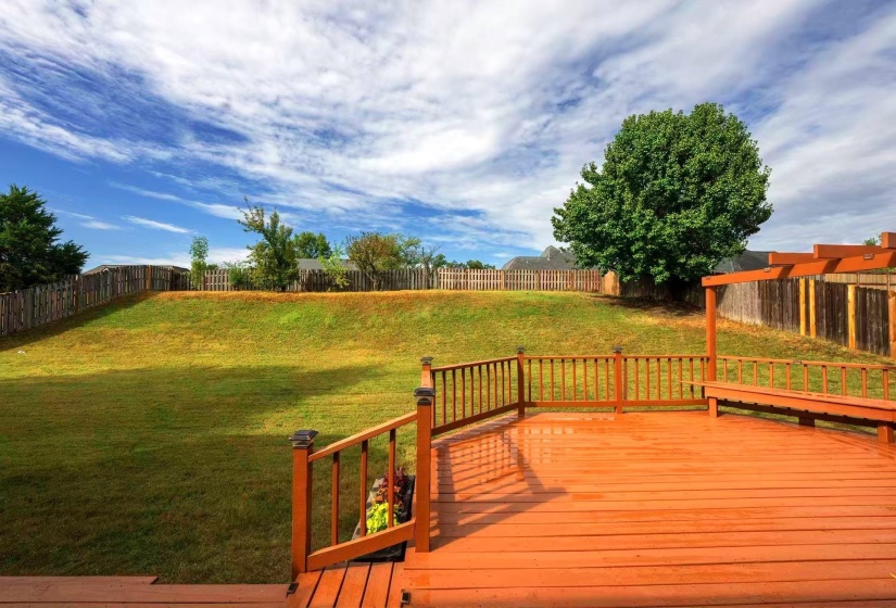 Spacious rear deck featuring a built-in bench and overhead pergola structure