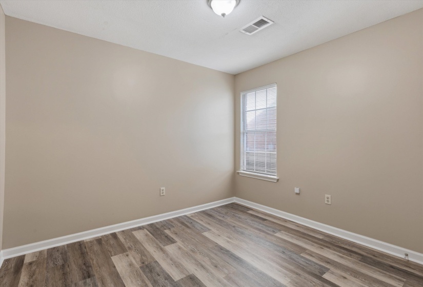 Room featuring neutral wall paint, wood-finish flooring, and white baseboards