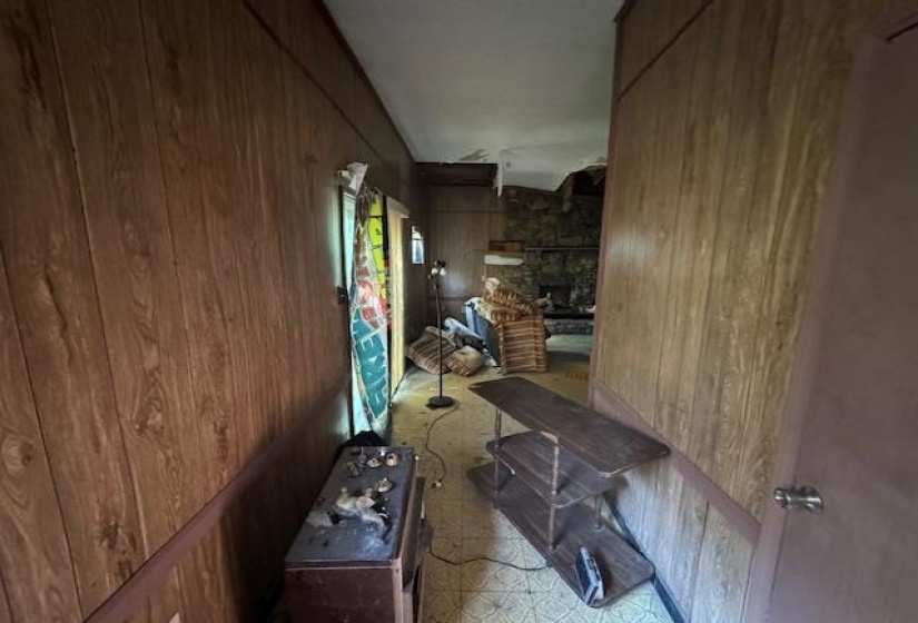 Hallway featuring wood-finish paneling and a light-colored floor