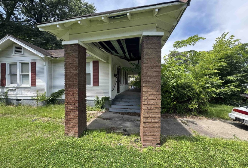 Front porch featuring two brick columns supporting an extended overhang