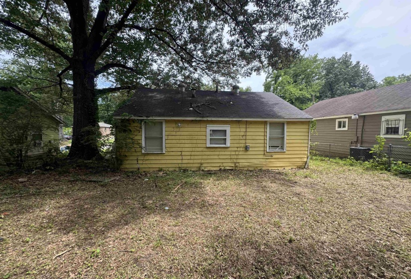 Rear exterior featuring yellow siding and multiple windows