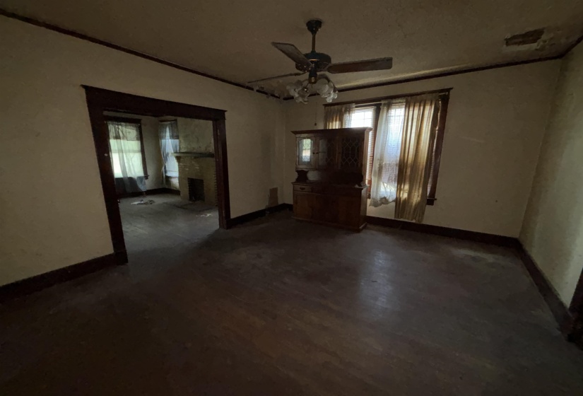 Wood-finish flooring throughout, featuring a ceiling fan with light fixture, and natural light from multiple windows