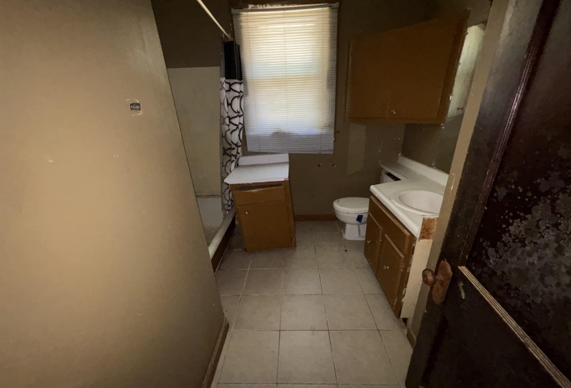 Bathroom featuring a tile floor, white toilet, and a vanity with an integrated sink