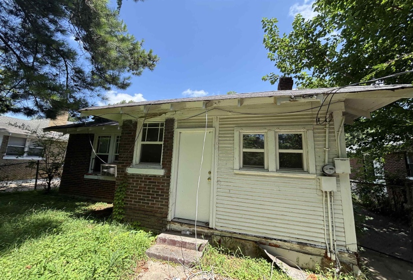 Rear exterior featuring a red brick section and a white siding addition
