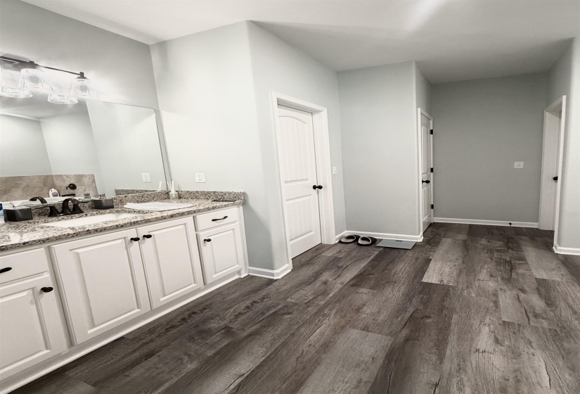 Dual vanity featuring white cabinetry, granite countertops, and undermount sinks