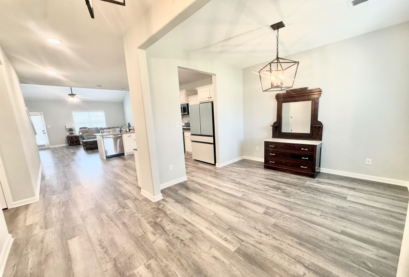 Light wood-finish flooring extending through an open-concept living area