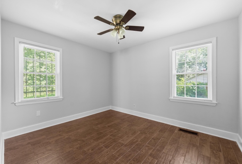 Room featuring wood-finish flooring, light gray walls, and white trim