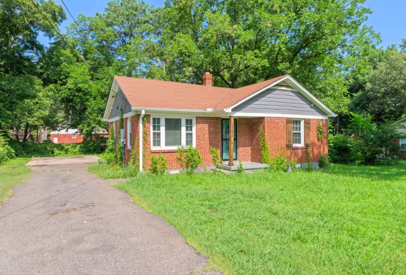 Brick exterior featuring a gabled roof, gray siding accent, and a front porch with supporting columns