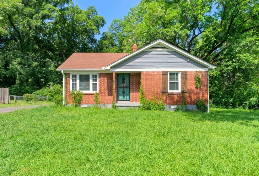 Brick exterior featuring a gabled roof and gray siding accents