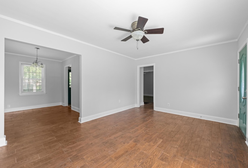 Spacious interior with wood-finish flooring, light gray wall paint, and white trim