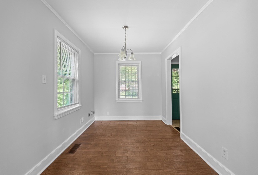 Bright interior space featuring light gray walls, wood-finish flooring, and white trim