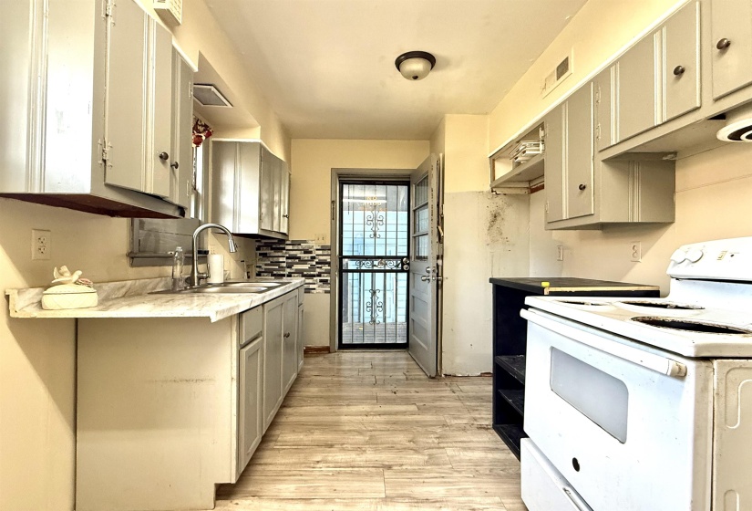 Kitchen featuring wood-finish flooring, gray cabinetry, and light-toned countertops
