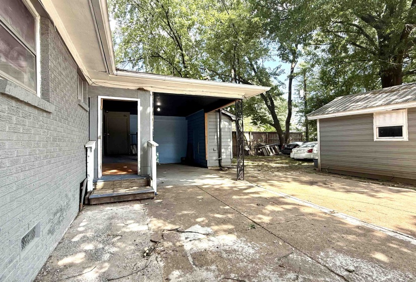 Concrete driveway leading to a covered carport