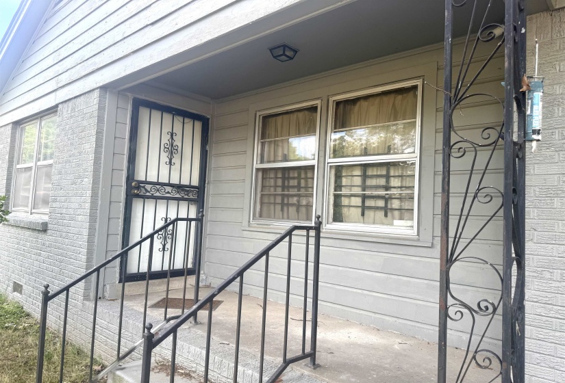 Front entry featuring a security screen door and wrought iron railings