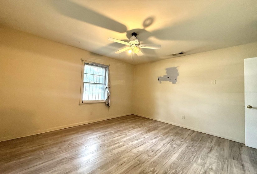 Room featuring wood-finish flooring, a ceiling fan with integrated lighting, and light-toned walls