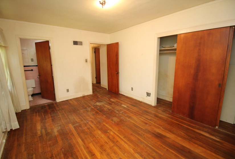 Hardwood flooring throughout, with a built-in closet featuring sliding wood doors