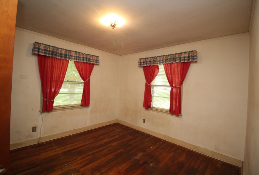 Room with two windows and wood-finish flooring
