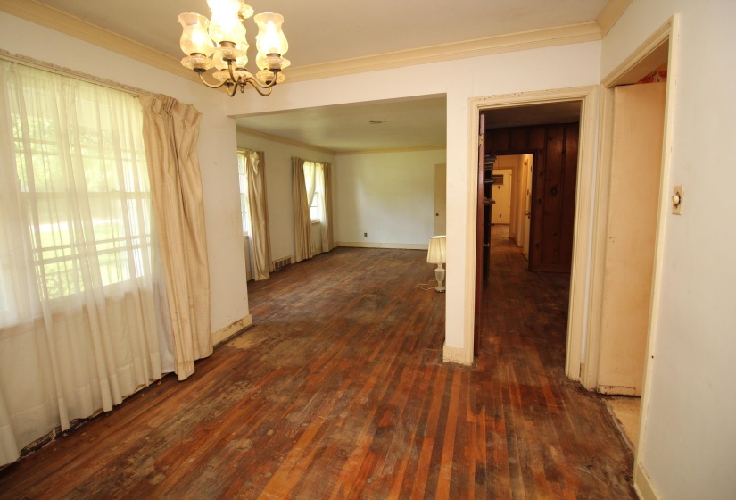 Interior space featuring wood-finish flooring, white walls, and a multi-light chandelier