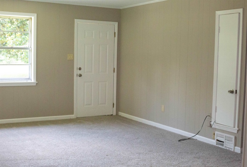 Neutral-toned paneled walls with white trim and light gray carpeting