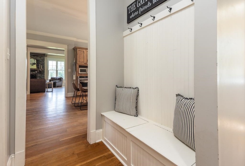 Entryway featuring built-in bench seating with beadboard paneling and coat hooks