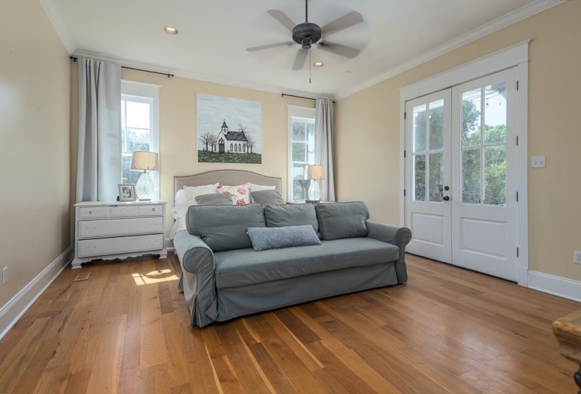 Hardwood flooring throughout this bright room featuring a ceiling fan, recessed lighting, and crown molding