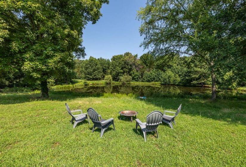 Expansive green space featuring a circular fire pit