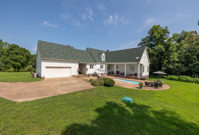 Exterior featuring white siding, a green shingle roof, and a two-car garage