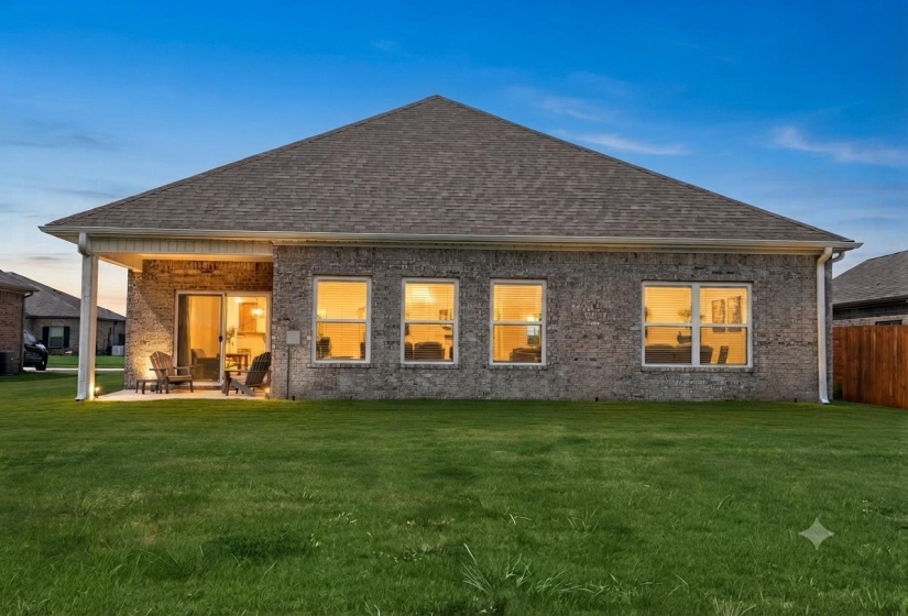 Rear exterior featuring a brick facade and a covered patio with recessed lighting