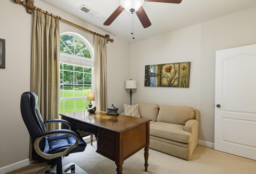 Split floor plan bedroom located off main living area with view of wooded front of the property.