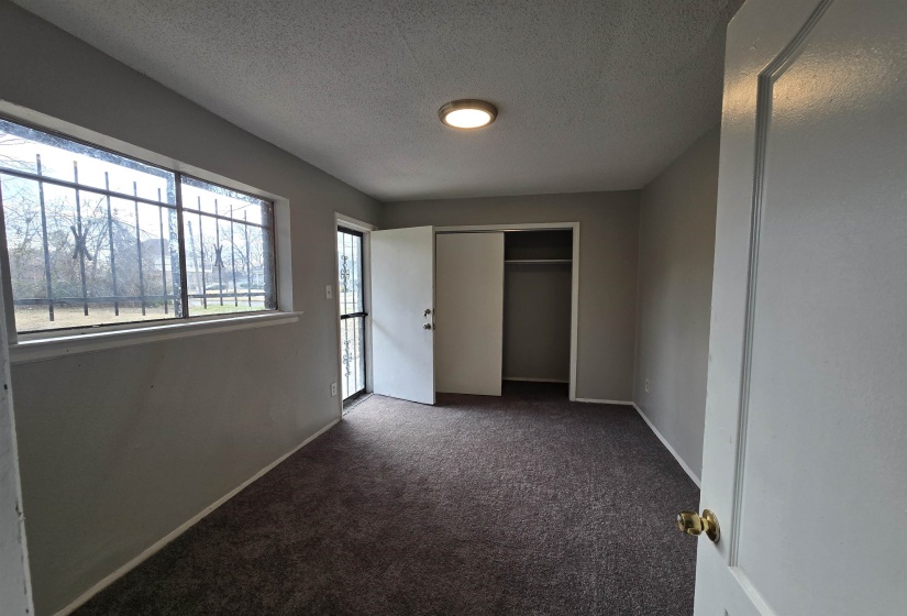 Unfurnished bedroom featuring a textured ceiling, carpet flooring, and a closet