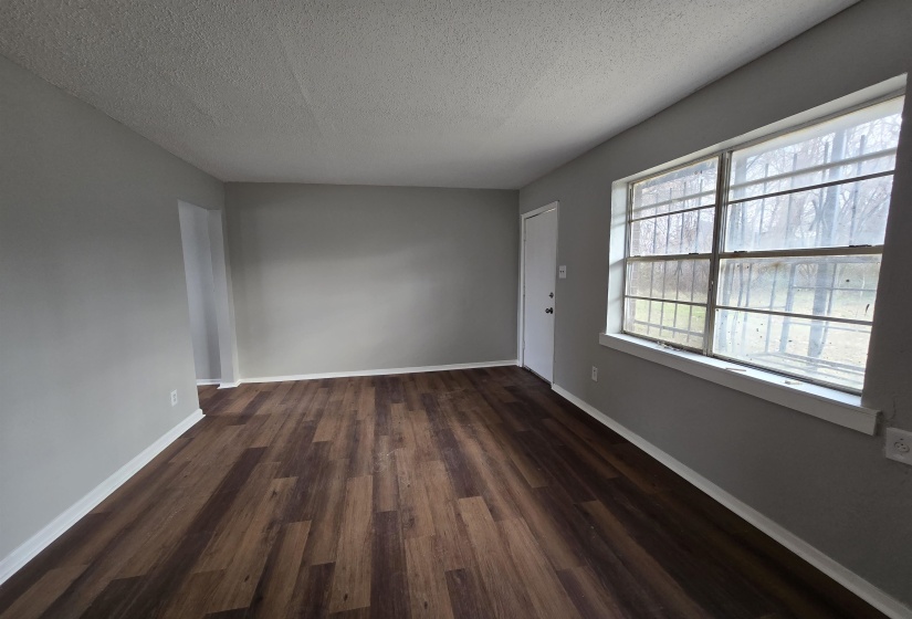 Empty room featuring dark wood-style floors and a textured ceiling