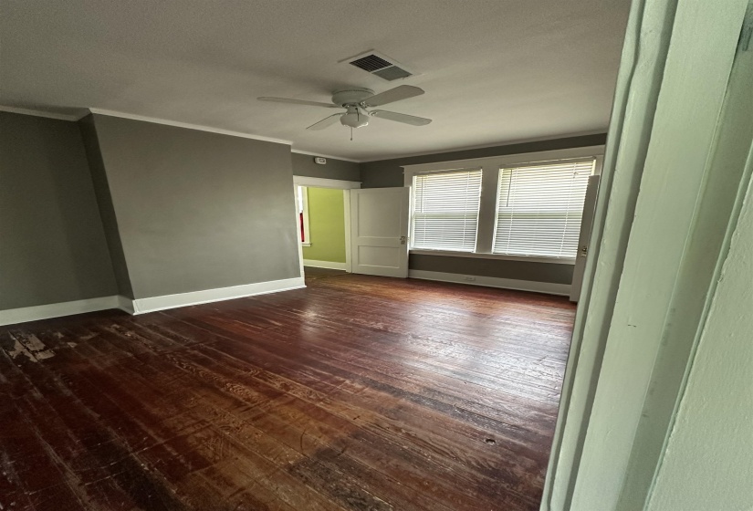 Interior space featuring wood-finish flooring, white baseboards, and a ceiling fan