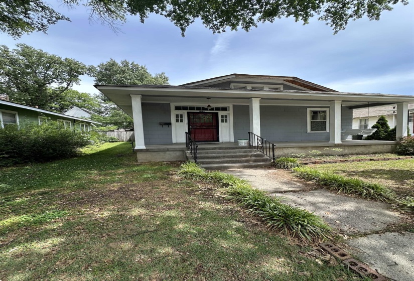 Craftsman-style home featuring a covered front porch with white columns, a red-painted front door with decorative glass, and gray siding