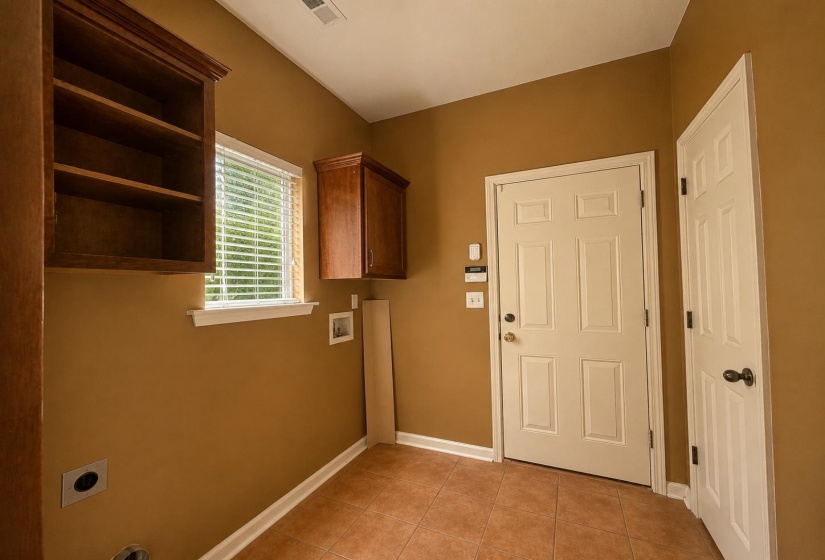 Laundry/Utility room with tile flooring, shaker-style cabinetry, and a window with blinds