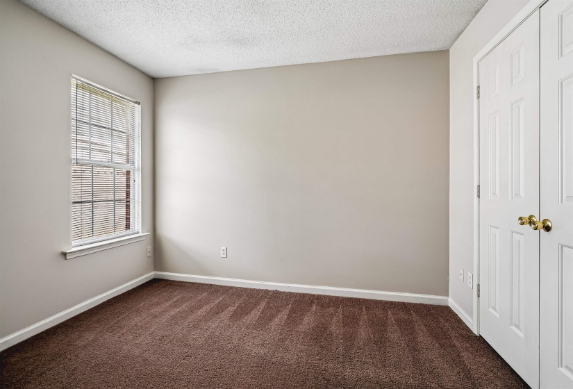 Room featuring neutral wall paint, white trim, brown carpet flooring, and a window with blinds