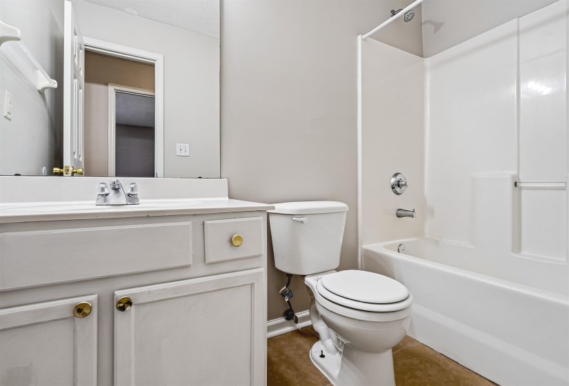 Bathroom featuring a white vanity with gold-tone hardware, a polished chrome faucet, and an integrated sink