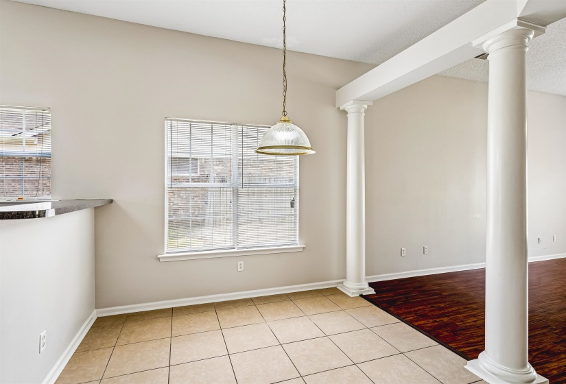 Dining area featuring a pendant light fixture, tile flooring, and two windows with blinds