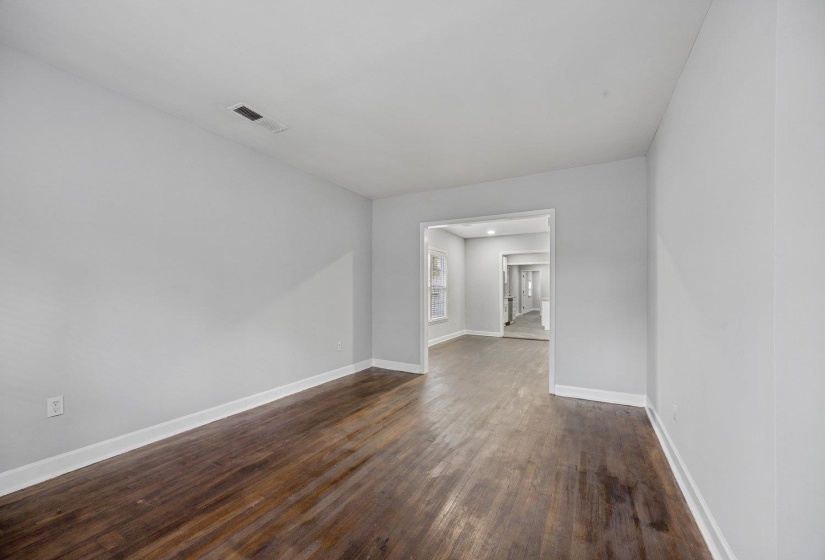 Empty room featuring dark wood-style flooring and baseboards